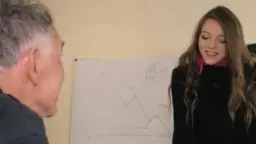 Grauhaariger Mann blickt von seinem Schreibtisch auf, während junge Brünette im schwarzen Kleid verführerisch in der offenen Bürotür steht.