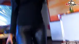 Junge Frau mit langen schwarzen Haaren kniet vor einem Mann und saugt gierig an seinem Schwanz