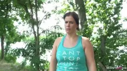 Reife Frau mit großen Brüsten steht selbstbewusst in türkisem Tanktop vor modernem Gebäude im Sonnenschein