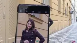 Dunkelhaarige Deutsche lächelt verführerisch und fasst sich in die Haare, während ein Mann ihr Geld hinhält